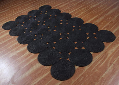 Black round braided rug made of natural fibers, ideal for modern home decor.
