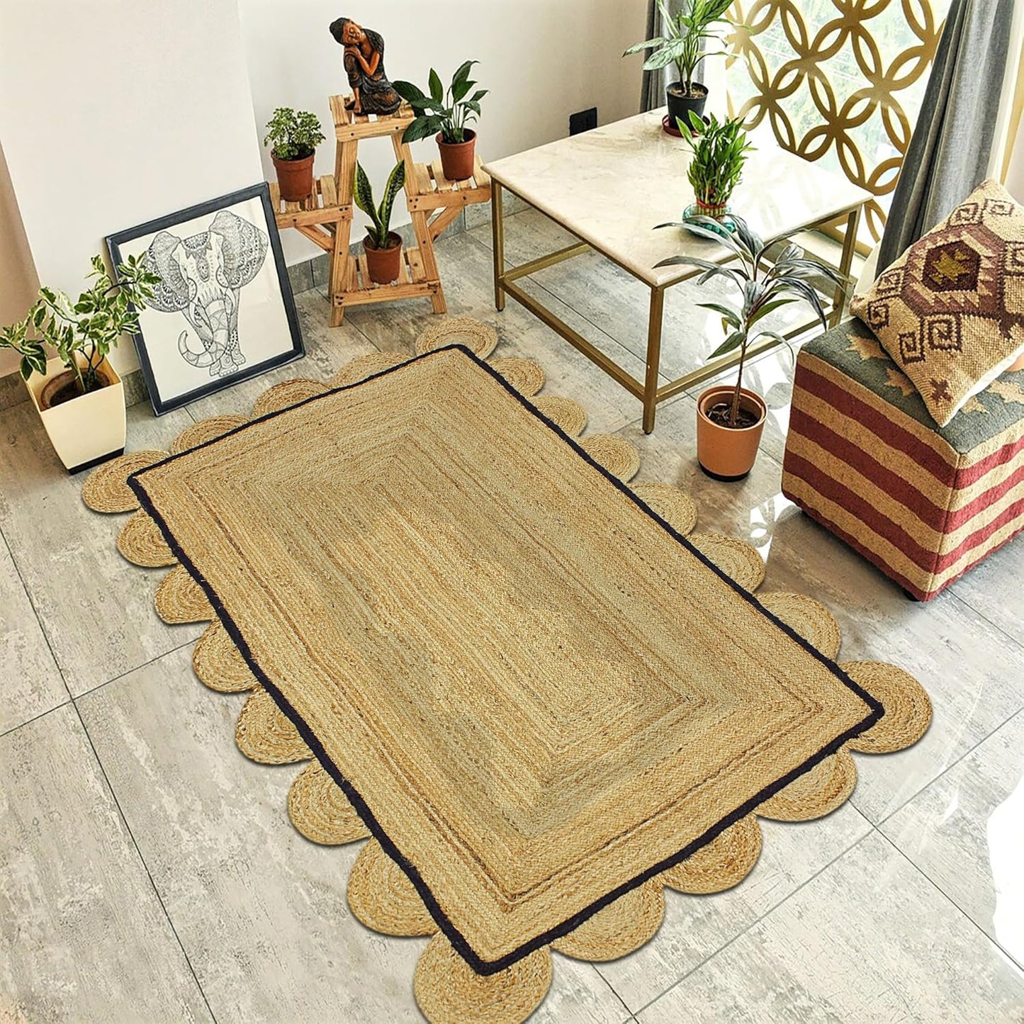 A rectangular natural jute area rug with scalloped edges and a dark border, styled in a modern living room setting on a light gray tiled floor.