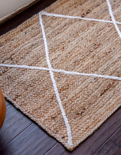 Textured beige rug with white geometric lines on a wooden floor.