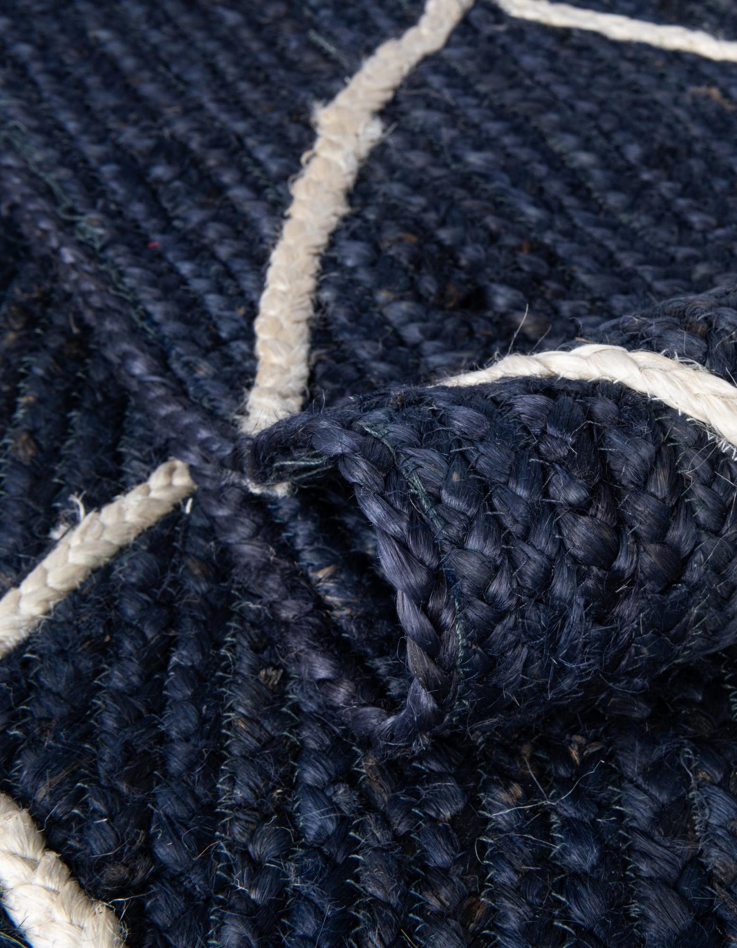 Close-up of a navy blue textured rug with white geometric patterns