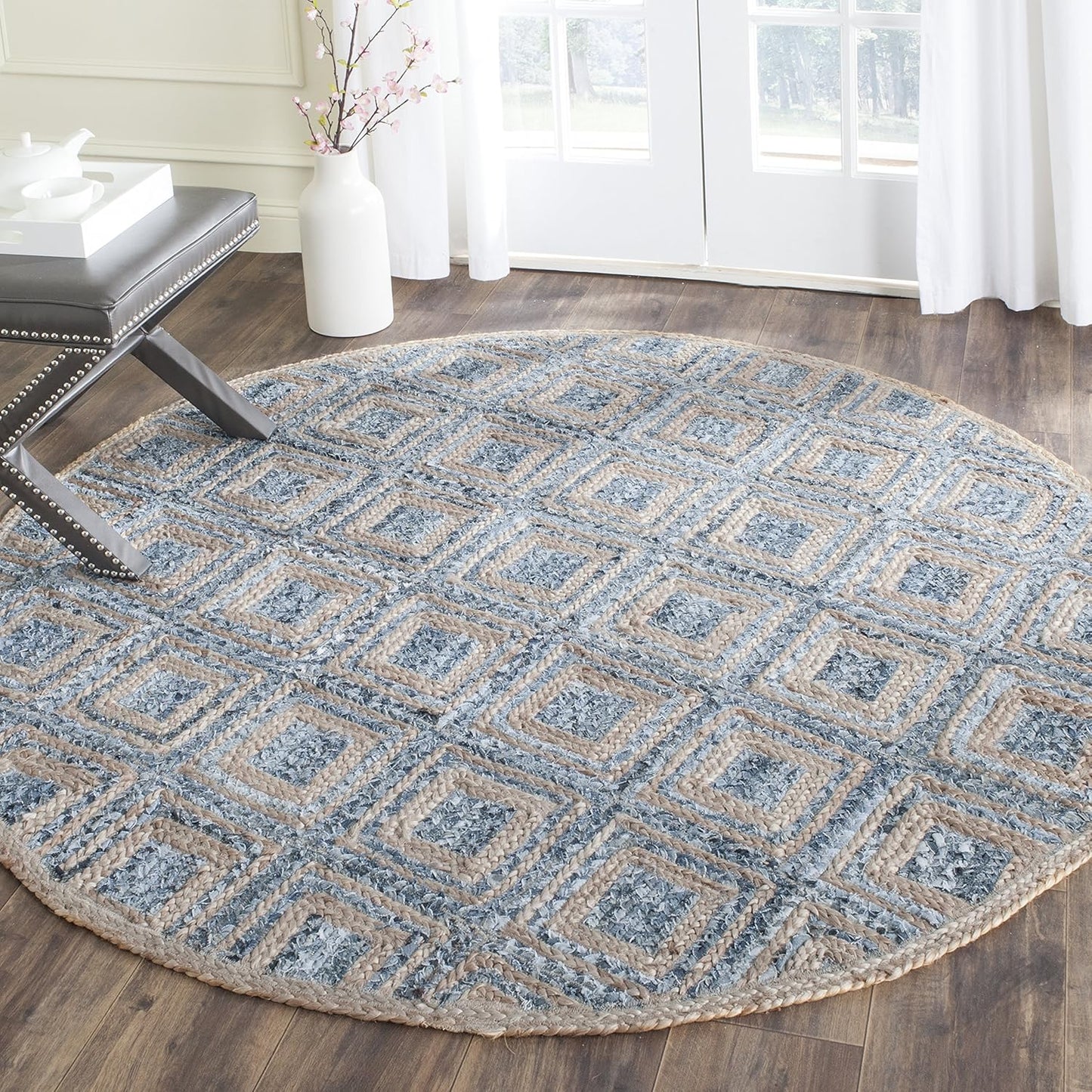 Round area rug with geometric pattern in blue and beige, made of braided natural fibers.