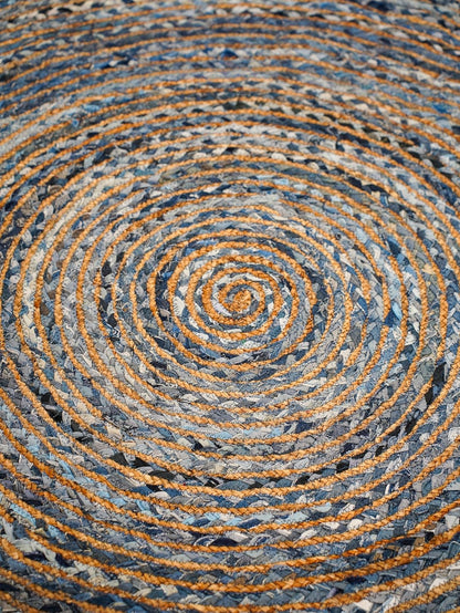 Circular braided rug in blue and orange hues made from durable fabric for home decor.