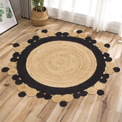 Round jute area rug with black and natural tones, featuring a decorative pom-pom edge.