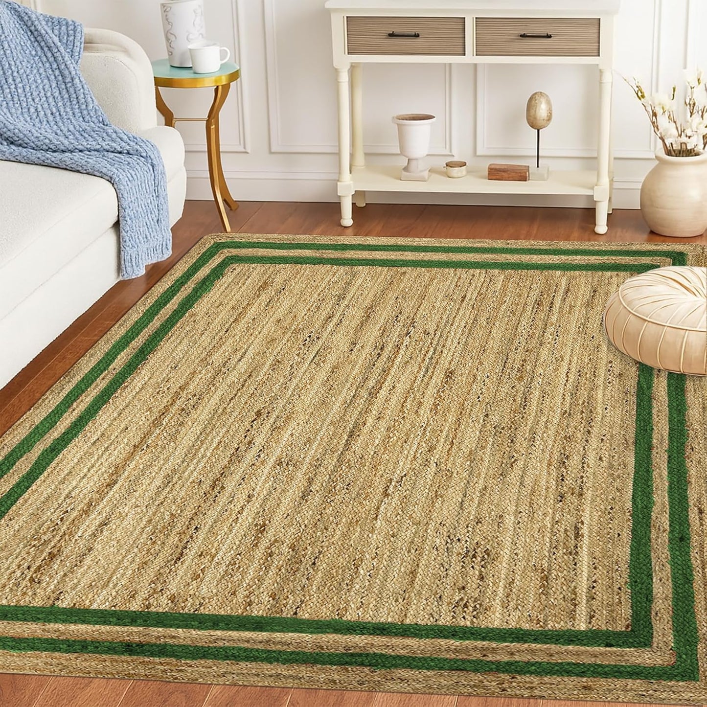 Natural Jute Area Rug with green border in a living room setting on hardwood floor next to a sofa and table.