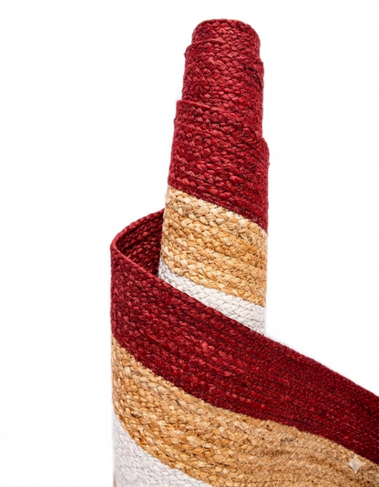 Close-up of a multicolored woven mat with red, beige, and white stripes on a white background.