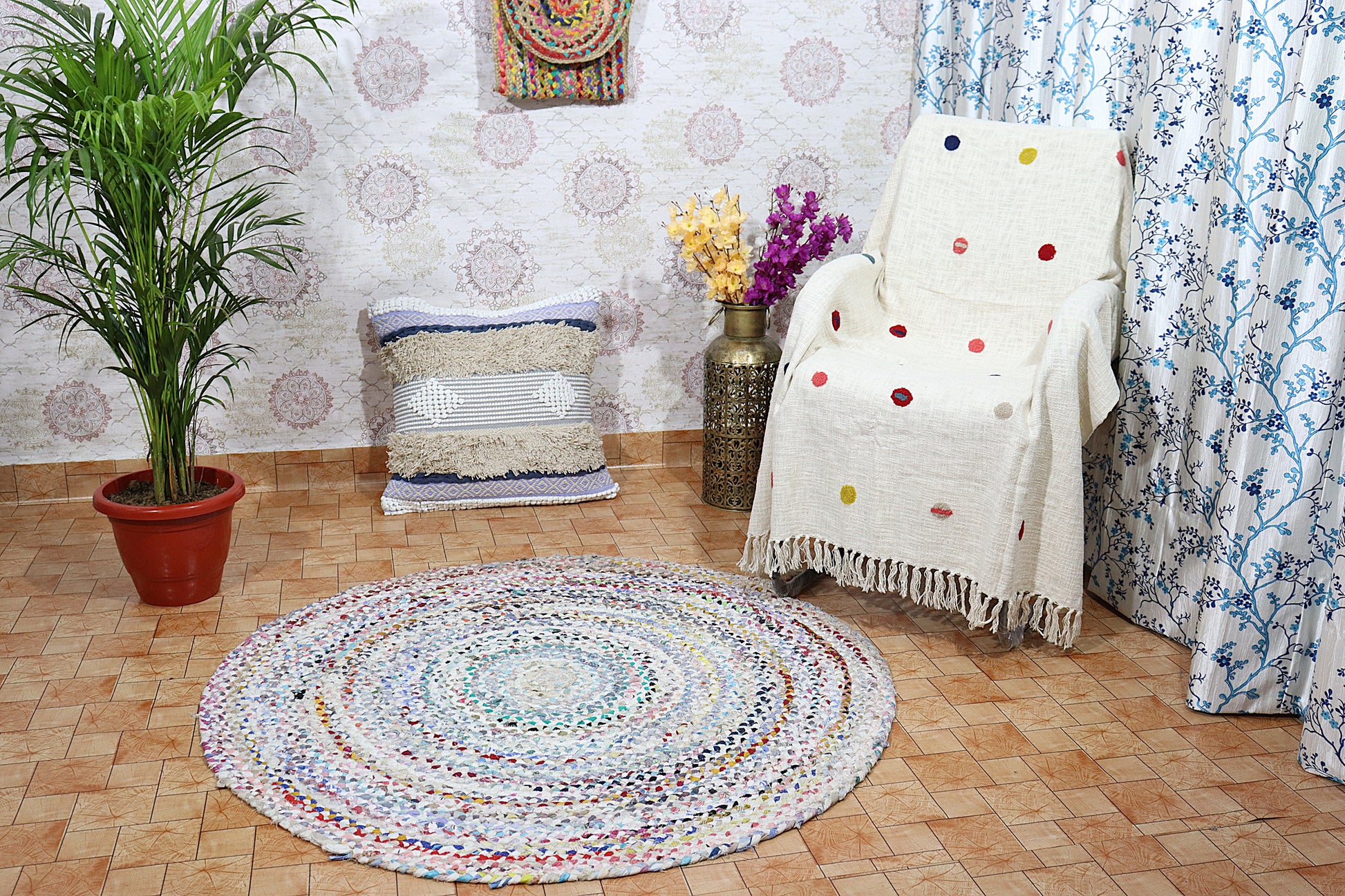 Living room with a round multicolored rug, polka dot blanket, and decorative pillows.