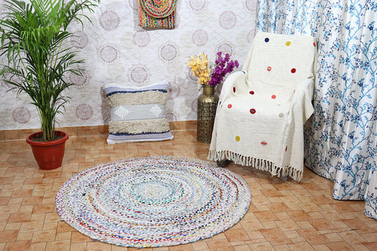 Living room with a round multicolored rug, polka dot blanket, and decorative pillows.