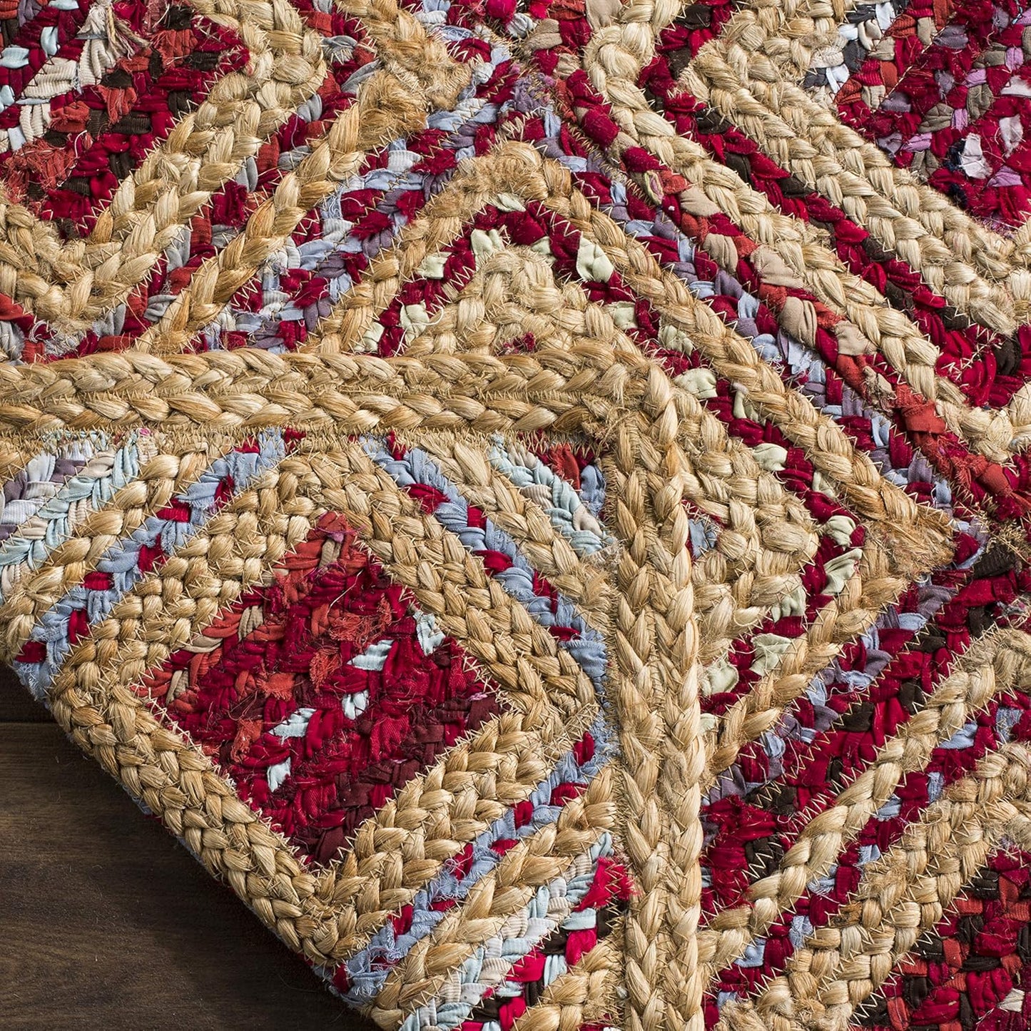 Handwoven braided area rug features red and blue patterns, made from natural fibers for a rustic decor.