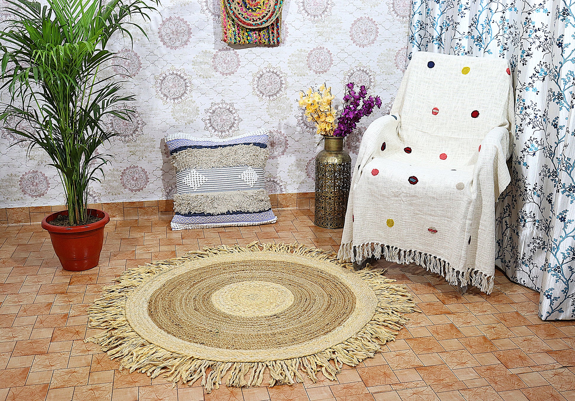 Living room with a round braided rug, white armchair with colorful polka dot blanket, and decorative pillows.