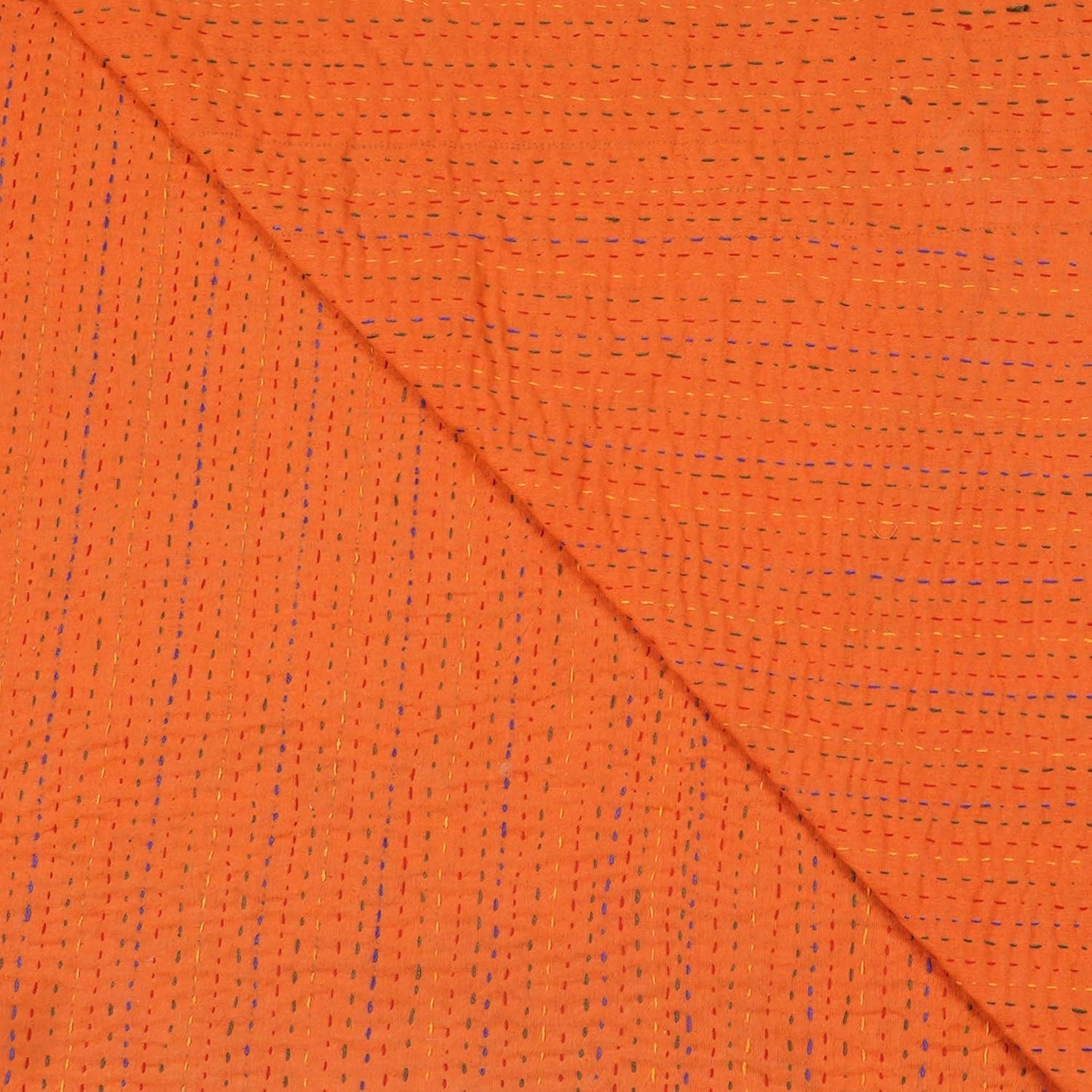 Close-up of orange fabric with a diagonal seam