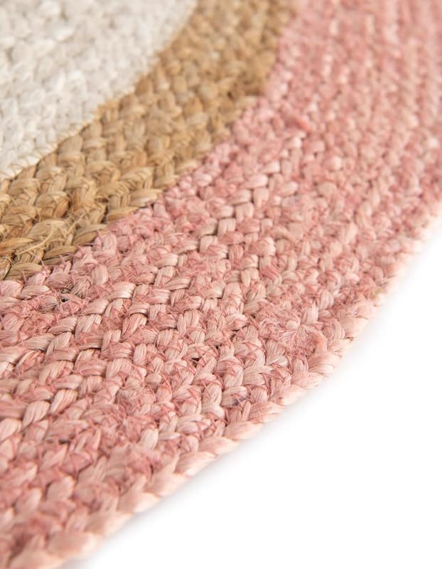 Handwoven round rug in pink, beige, and white colors; made from natural fibers for a cozy home accent.