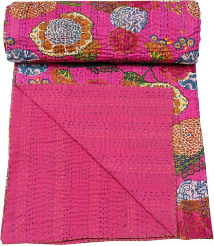 Pink floral patterned quilt with a folded edge on a white background