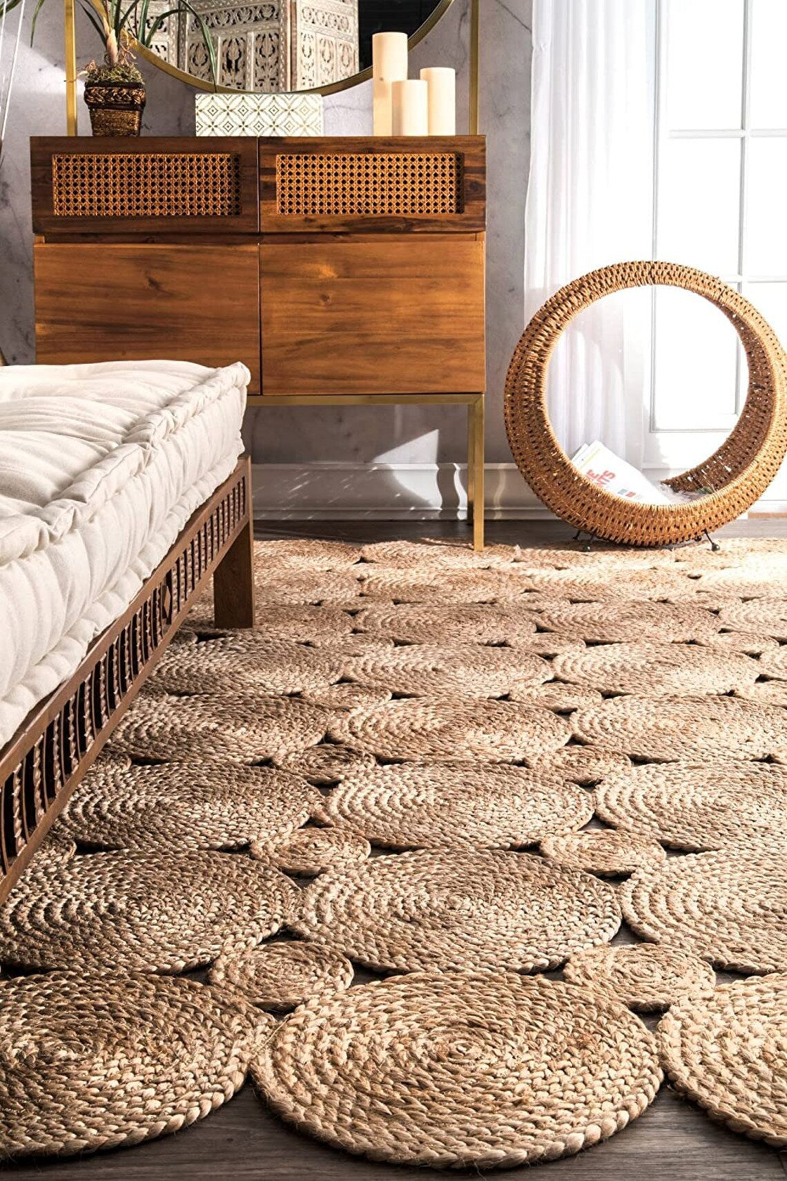 Woven jute rug in a room with wooden furniture and large round mirror.