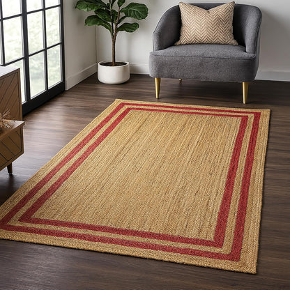 Natural Jute Area Rug with red striped border in a modern living room setting on dark wood flooring