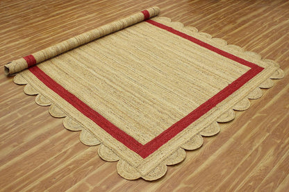 Natural Jute Area Rug with a scalloped edge and red border, enhancing any living space with its earthy texture.