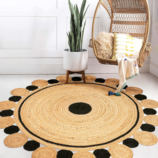 Round jute rug with black accents in a room with a hanging chair and plant.