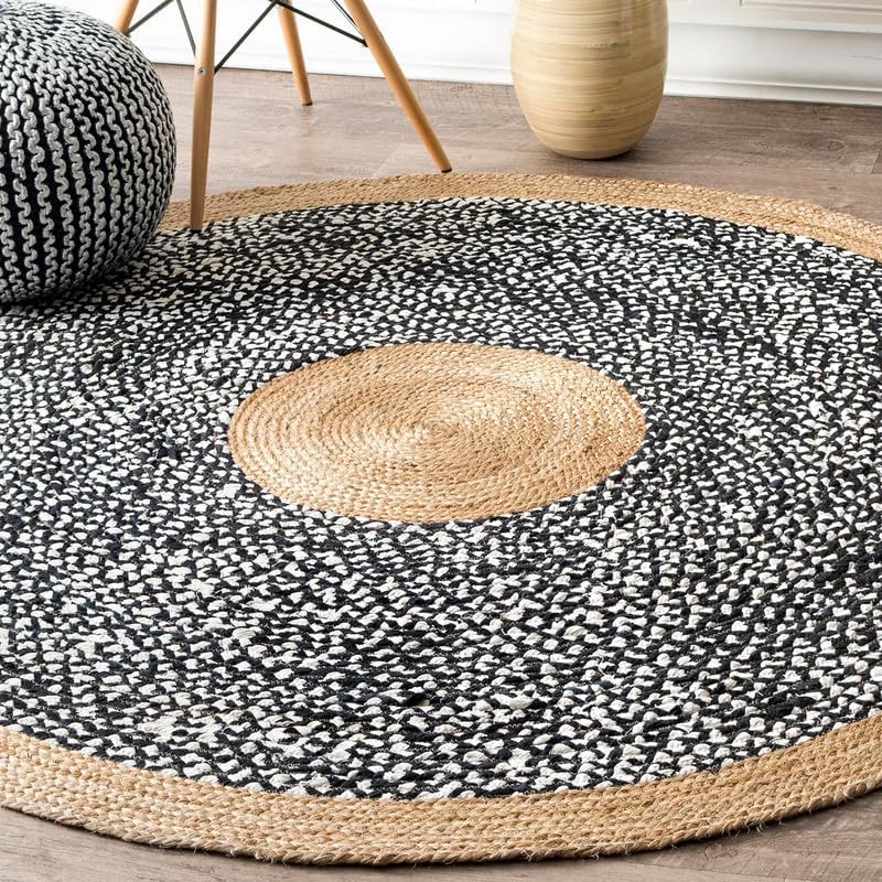 Round black and white patterned rug with a central circular design on a wooden floor.
