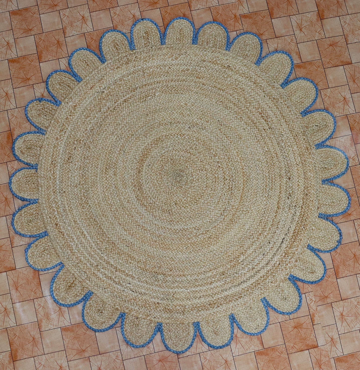 Round braided rug with blue border on a tiled floor