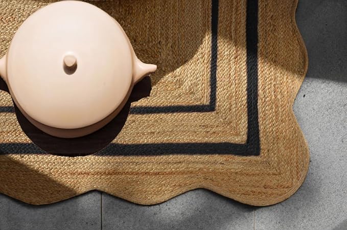 Beige ceramic teapot on a textured doormat with a black border.