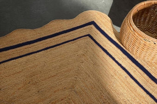 Coir mat with blue stripes next to a woven basket on a dark surface