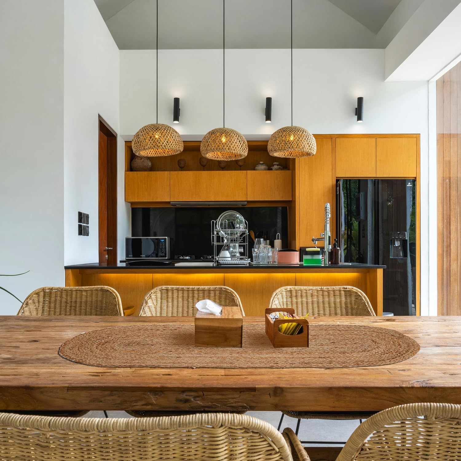 Modern kitchen with wooden dining table and chairs, and a view of the kitchen area.