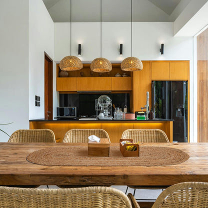 Modern kitchen with wooden dining table and chairs, and a view of the kitchen area.