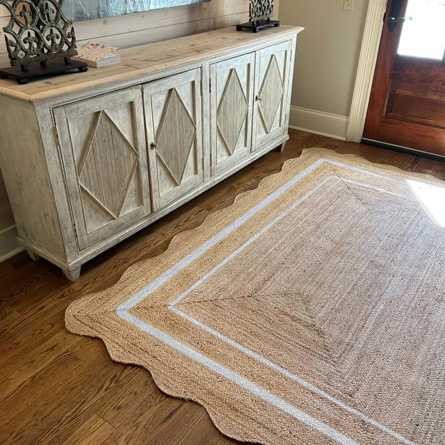 Beige area rug with geometric pattern on wooden floor next to a wooden sideboard.