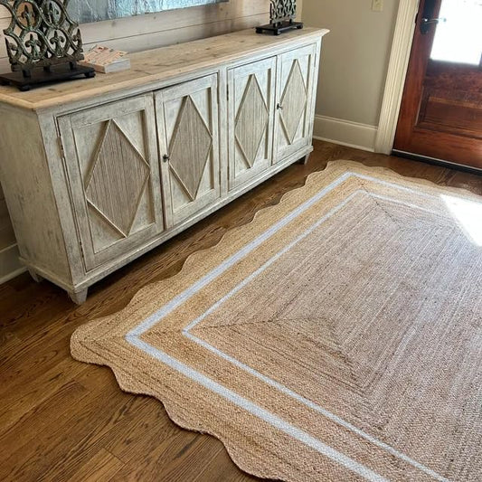 Beige area rug with geometric pattern on wooden floor next to a wooden sideboard.