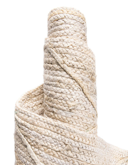 Close-up of a roll of beige rope on a white background