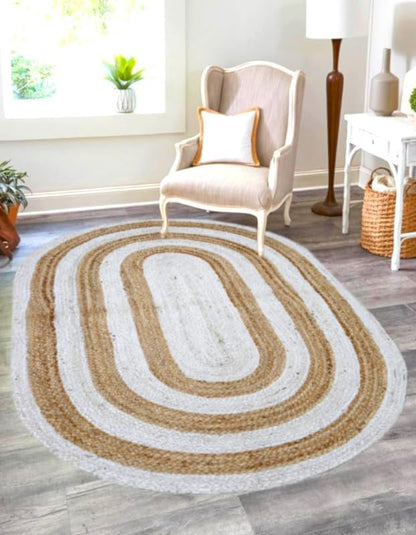 Oval jute area rug in beige and white, featuring a braided design, perfect for cozy home decor.