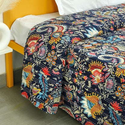 Colorful floral-patterned quilt on a bed with a yellow headboard.