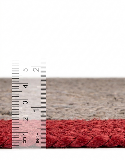 Red textured yarn with a ruler for scale on a neutral background