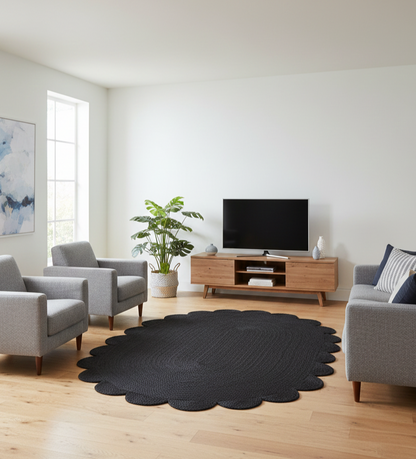 Living room with a black round rug, gray chairs, and a TV stand.