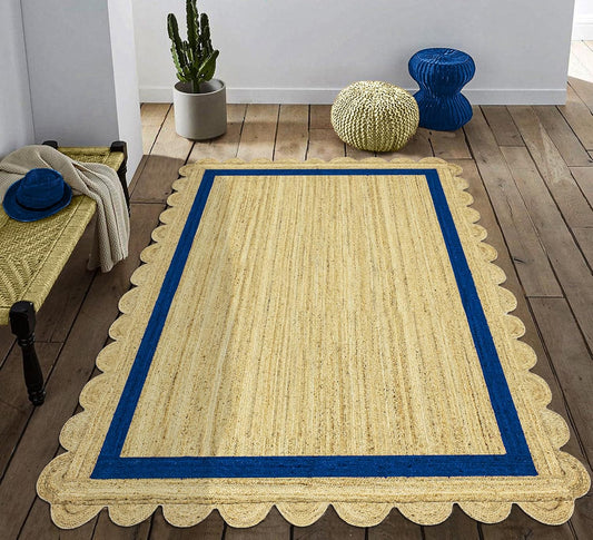 Natural Jute Area Rug with a scalloped edge and blue border, enhancing a cozy indoor space with earthy texture.