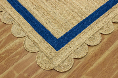 Natural Jute Area Rug with scalloped edges and navy blue trim, perfect for adding texture to any living space.