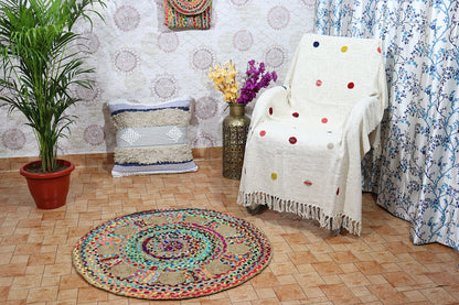 Living room with a colorful rug, chair, plant, and decorative items.