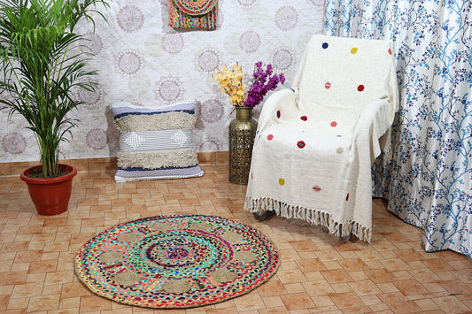 Living room with a colorful rug, chair, plant, and decorative items.