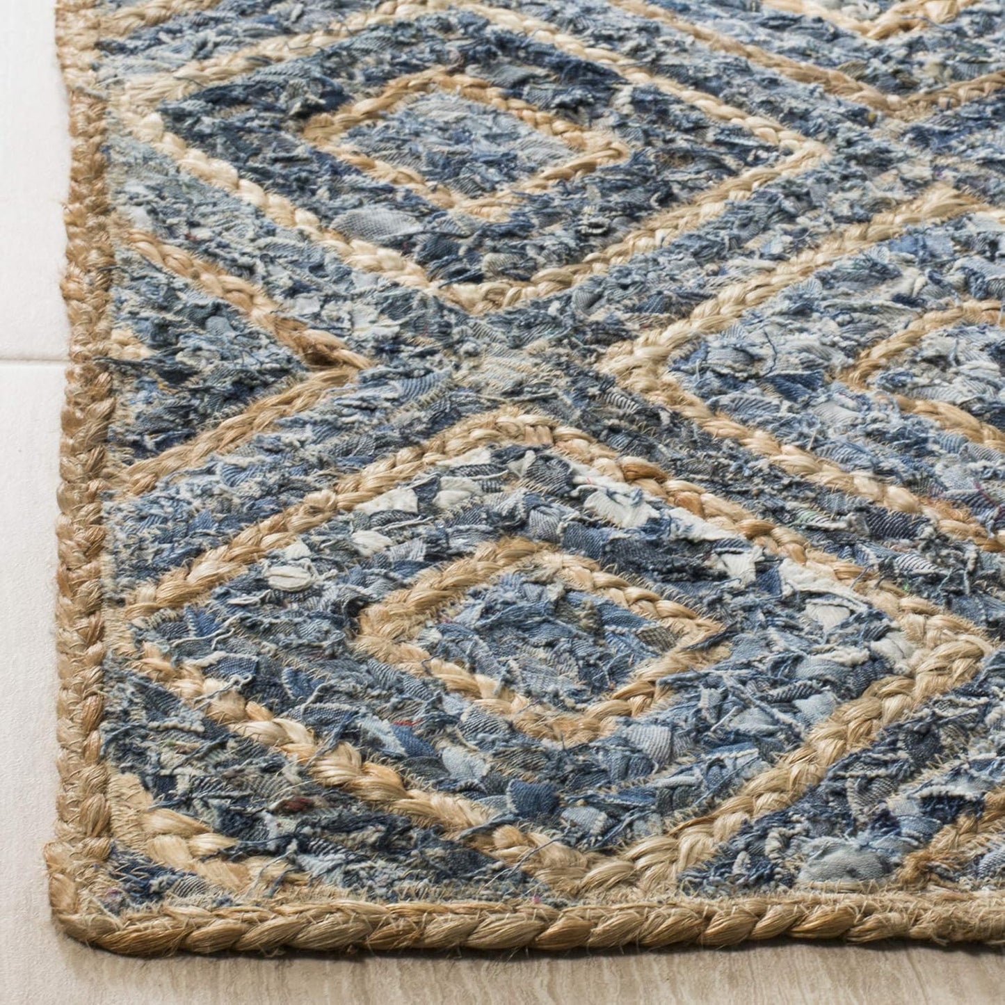 Blue woven area rug with diamond pattern, made from recycled denim and jute, adding texture and style.