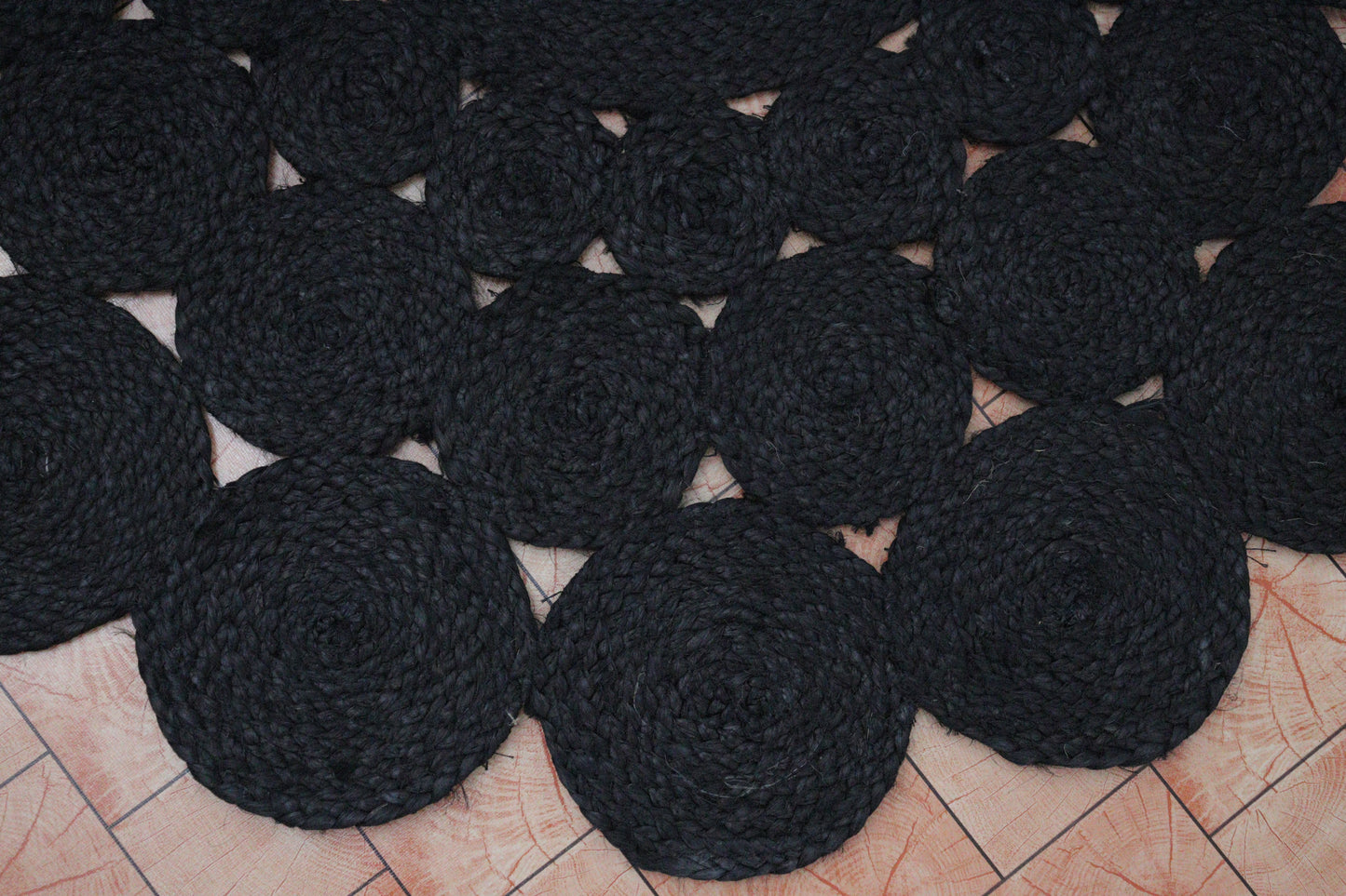 Black circular coasters arranged on a tiled floor