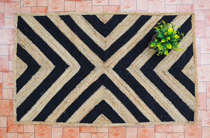 Doormat with black and beige chevron pattern on a tiled floor