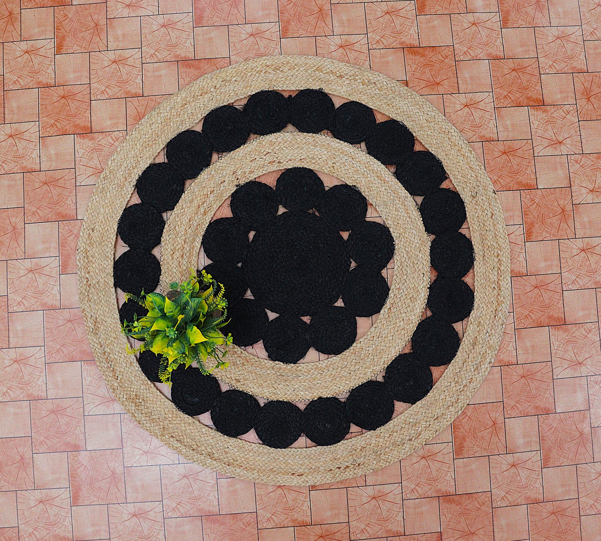 Round woven rug with black and beige pattern on a tiled floor