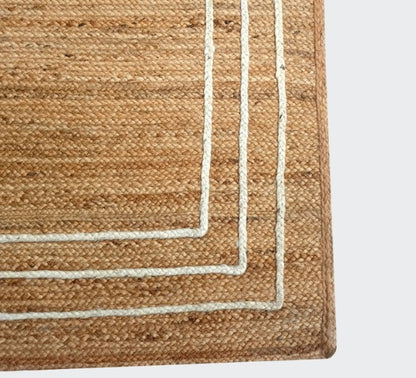 Close-up of a woven rug with a striped border on a light gray background