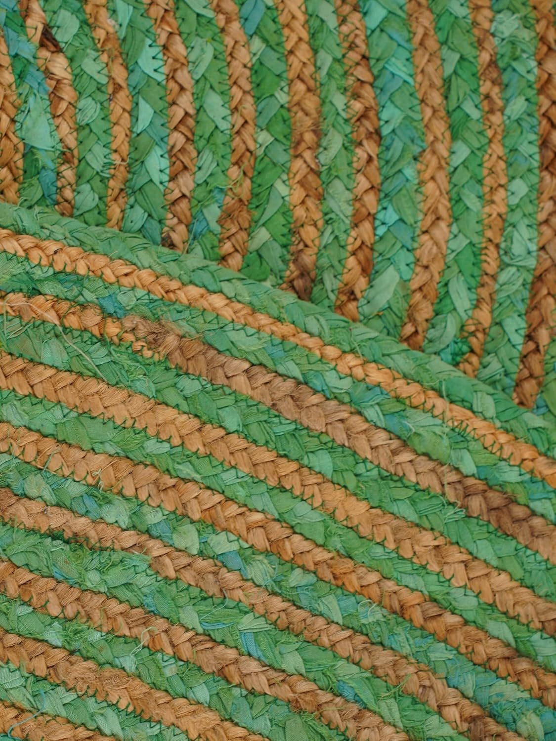 Handwoven green and brown straw mat, featuring a striped design, perfect for home decor or outdoor use.