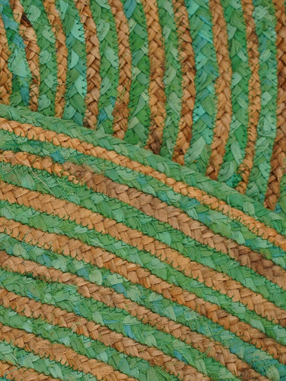 Handwoven green and brown straw mat, featuring a zigzag pattern, perfect for home decor or picnics.