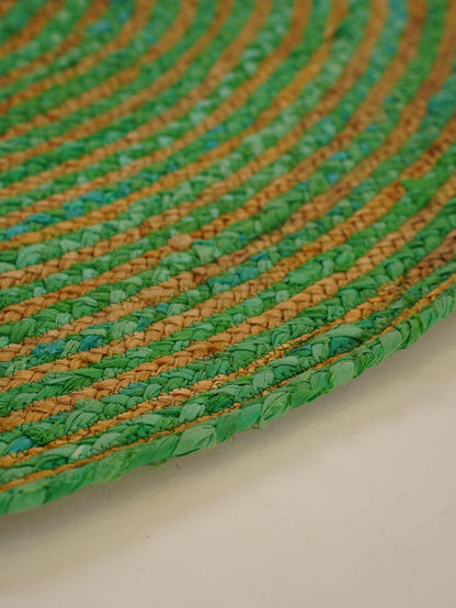 Handwoven green and tan braided rug, made from natural materials, adding eco-friendly charm to your decor.