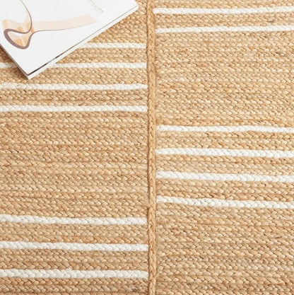 Beige woven rug with white stripes and a corner of a magazine visible.