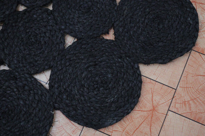 Black woven coasters on a textured surface