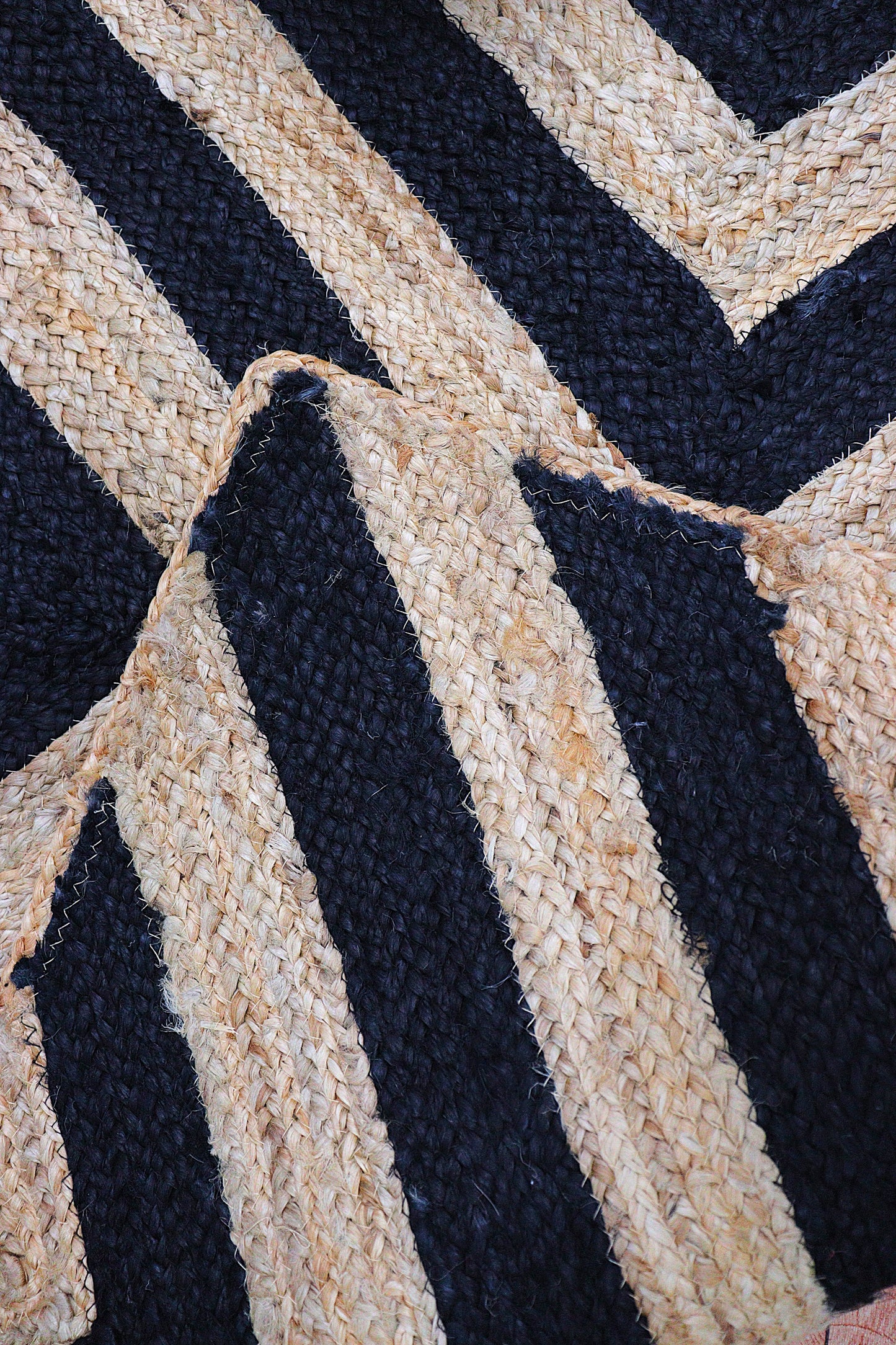 Close-up of a woven fabric with black and beige chevron pattern