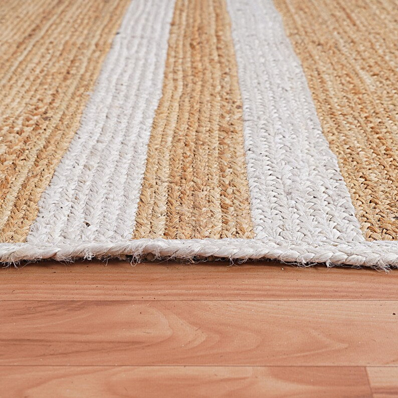 Striped jute rug with beige and white stripes on a wooden floor
