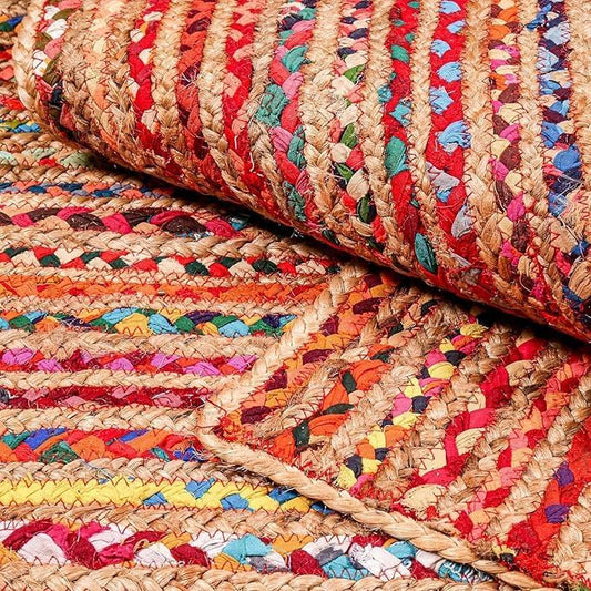 Close-up of a multicolored braided rug with red, blue, green, and beige patterns.